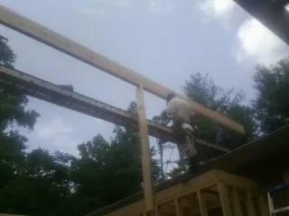 Carpenter setting a ridge beam over a new addition frame — Ice Dam Removal by Roofing Brothers in Bridgeport