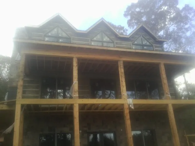 Dormers and porch framing on a large log home under construction — Roof Coating work by our crew in Bridgeport